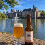 Kleintje Eiber Brut IPA, glas en fles aan de Hofvijver in Den Haag met fontein en het Binnenhof op de achtergrond