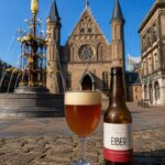 Eiber ZHB IPA, glas en fles op de kasseien van het Binnenhof in Den Haag voor de Ridderzaal en de fontein